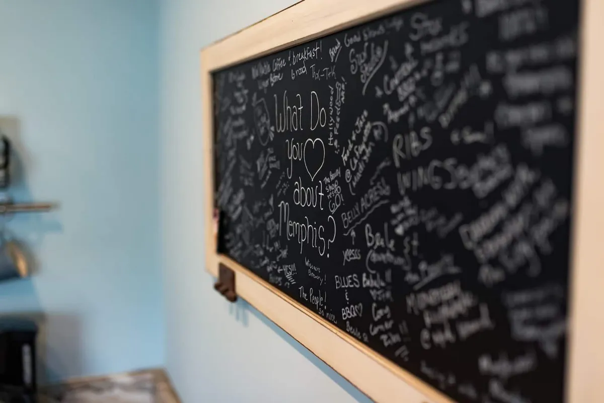 This image features a chalkboard filled with handwritten messages and notes, suggesting a welcoming and community-oriented environment. The chalkboard likely contains recommendations, personal stories, or local tips shared by guests, fostering a sense of connection to the neighborhood and its attractions.